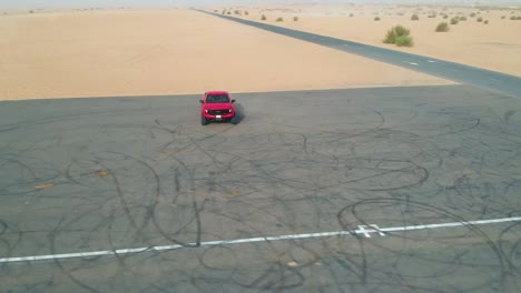 red truck parked on tarmac road before desert
