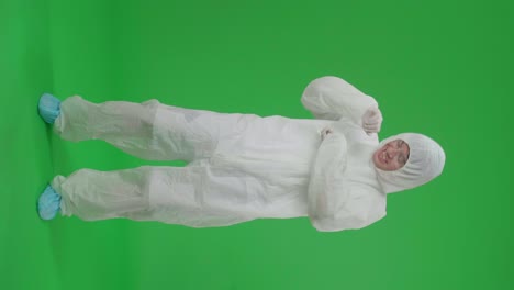 full body of asian male wearing personal protective equipment uniform ppe and dancing in green screen studio