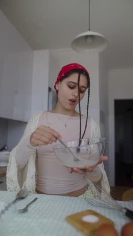 young woman mixing ingredients in kitchen
