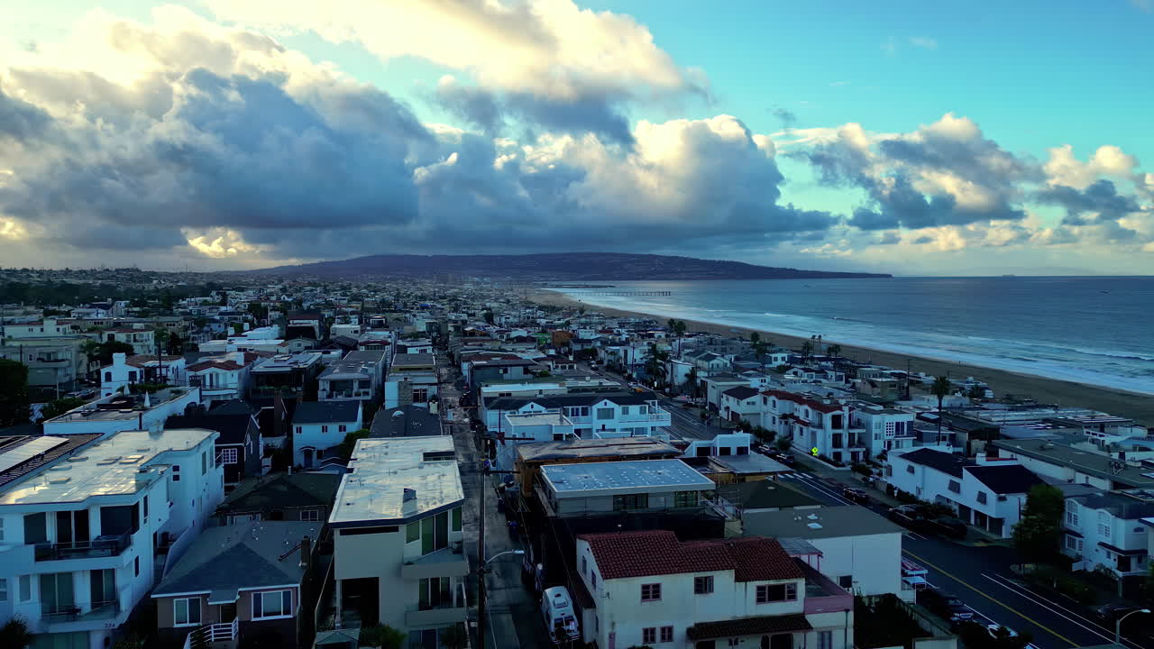 Panoramica aerea di edifici vicino a Manhattan Beach con onde luminose che si infrangono sulla costa affollata