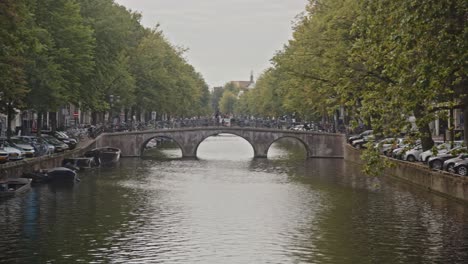 wide pan of distant bridge and quays on amsterdam canal