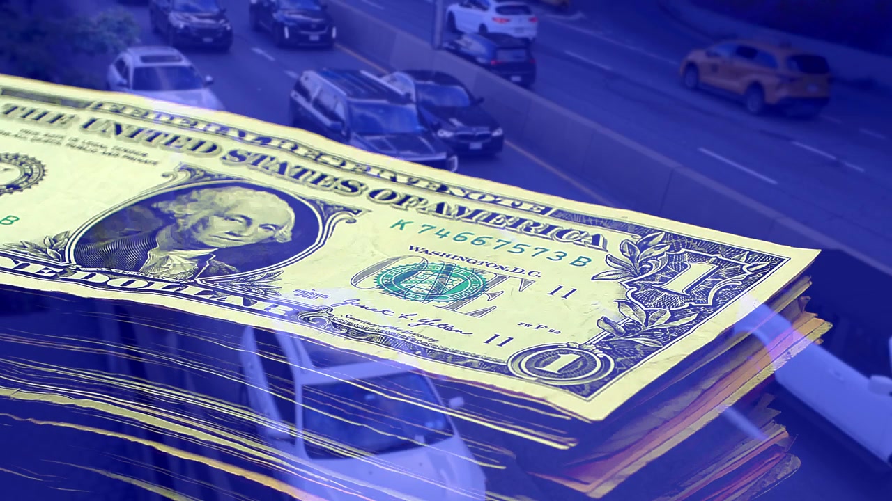 Double exposure concept of mixed US dollar bills stack shrinking over congested city road traffic. Visual metaphor for inflation, shrinking savings, and urban financial strain. Blue Color.
