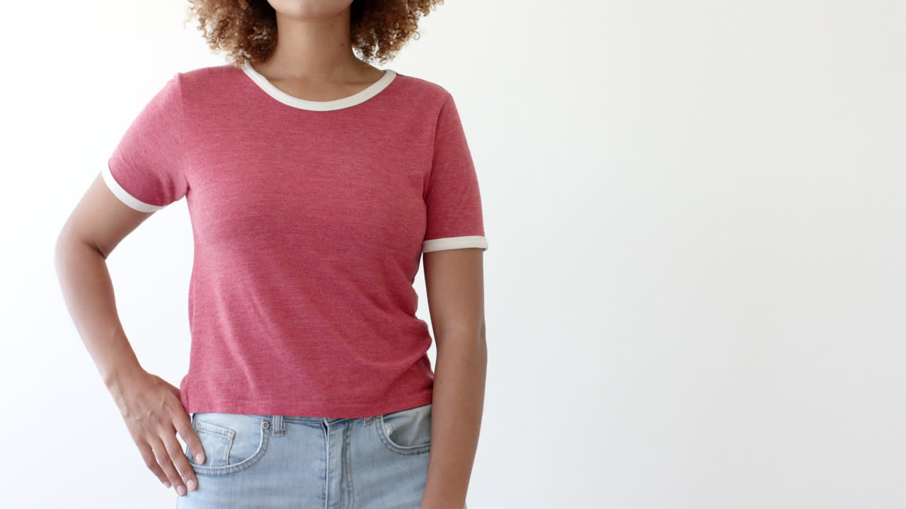 sección media de una mujer afroamericana con una camiseta roja con espacio de copia en fondo blanco.
