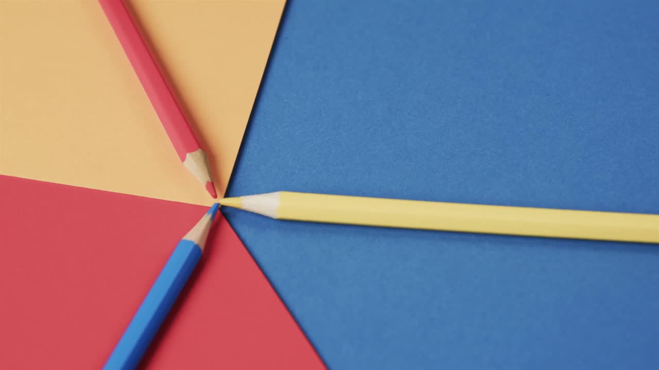 primer plano de lápices de colores sobre un fondo colorido, en cámara lenta