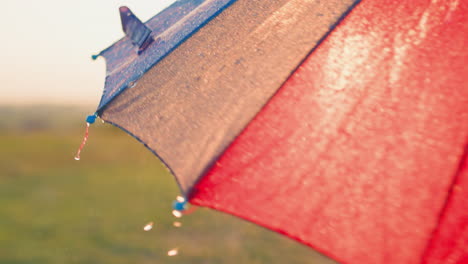 las gotas de lluvia crean cascadas con cada rotación las gotas de agua caen por el colorido paraguas