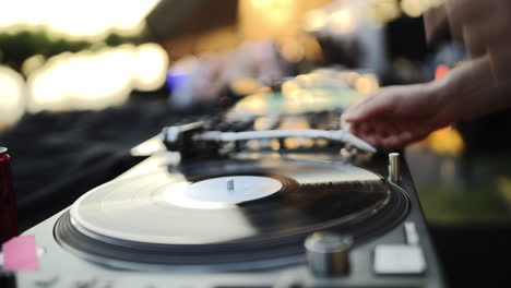 DJ-Placing-Tonearm-on-Vinyl,-Spinning-Turntable-at-an-Event-Party