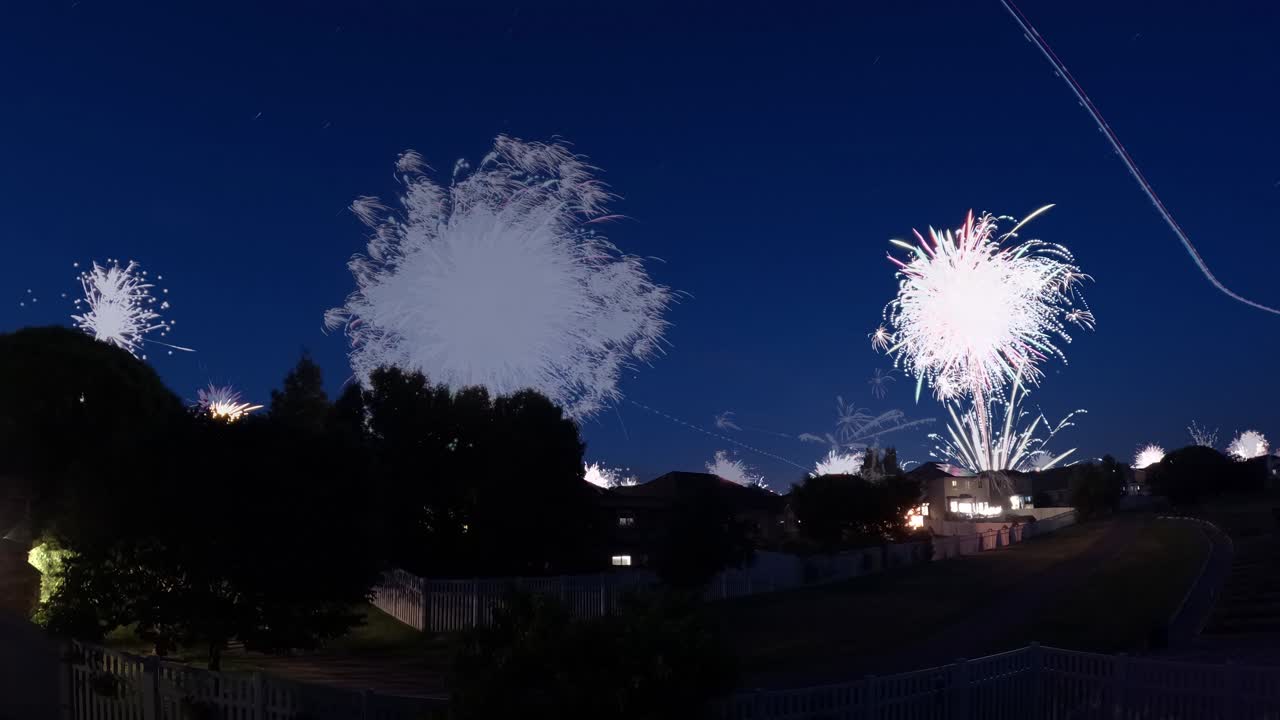 fuegos artificiales sobre un barrio suburbano - rastros de luz efecto de lapso de tiempo