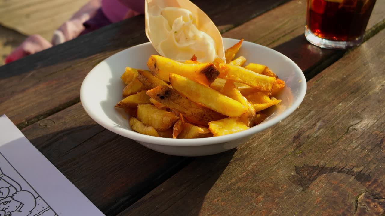 Bowl with handmade golden fresh fat French fries and cup of mayonaise