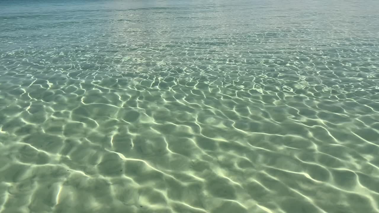sunlight sparkles on transparent shallow sea at cala ses covetes mallorca spain
