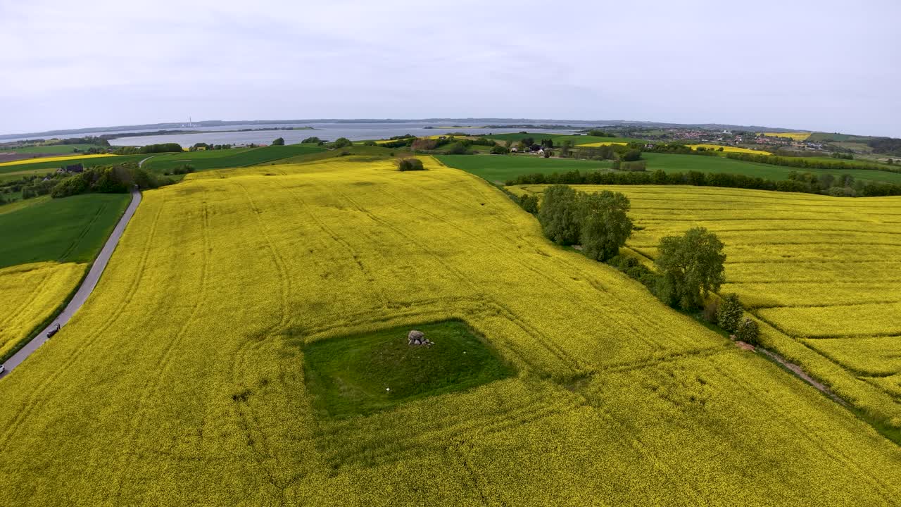 Drone footage captures a lush green field with a distinct rectangular patch and surrounding countryside roads