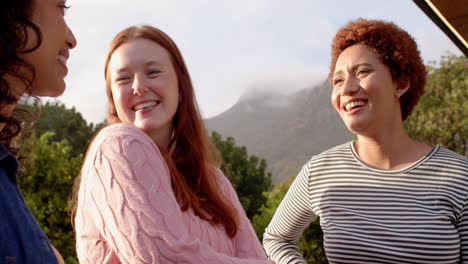 enjoying outdoor hangout, diverse female friends smiling and laughing together