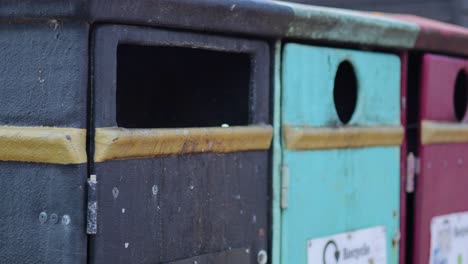 persona arroja conchas de ostras en el contenedor de basura
