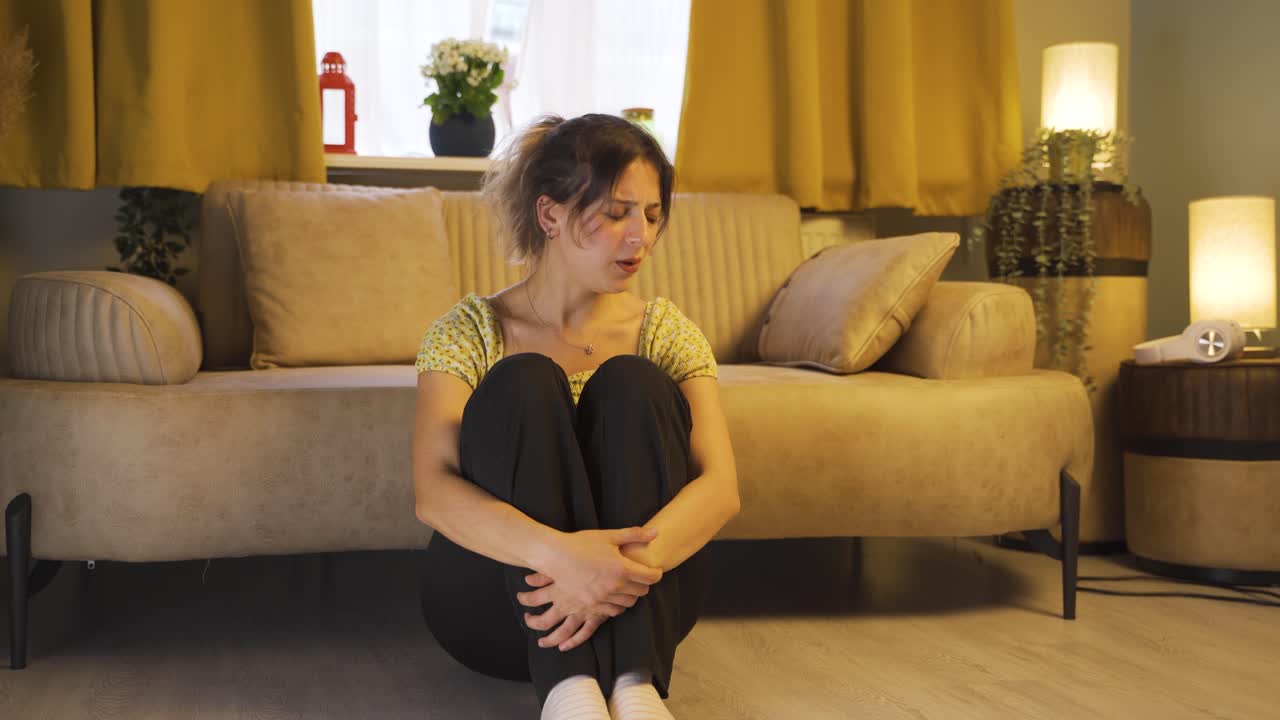 Giovane donna malata che tossisce, appoggiata al muro. Senza speranza.