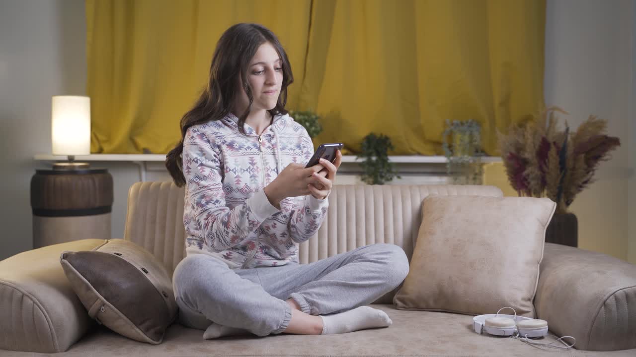 밤에 집에 있을 때, 화를 내는 젊은 여성은 짜증이 나고 전화 메시지에 변덕스럽습니다.
