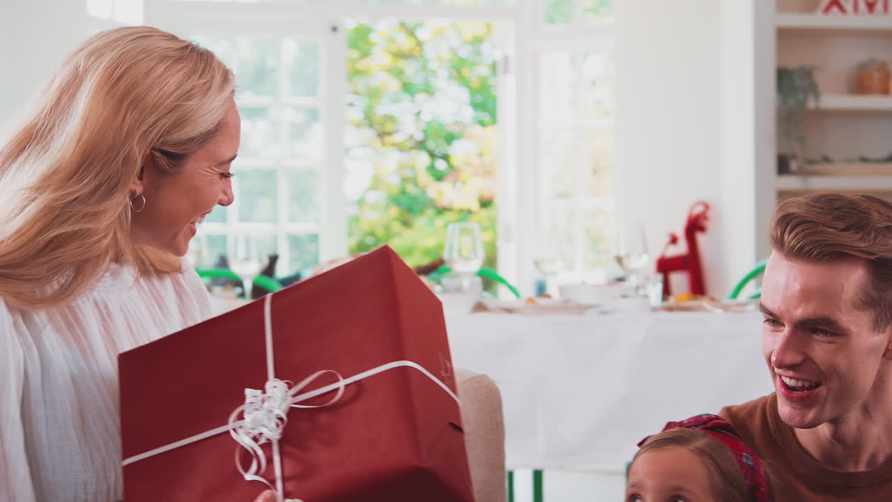 집 에서 크리스마스 를 축하 하고 함께 선물 을 열고 있는 다세대 가족