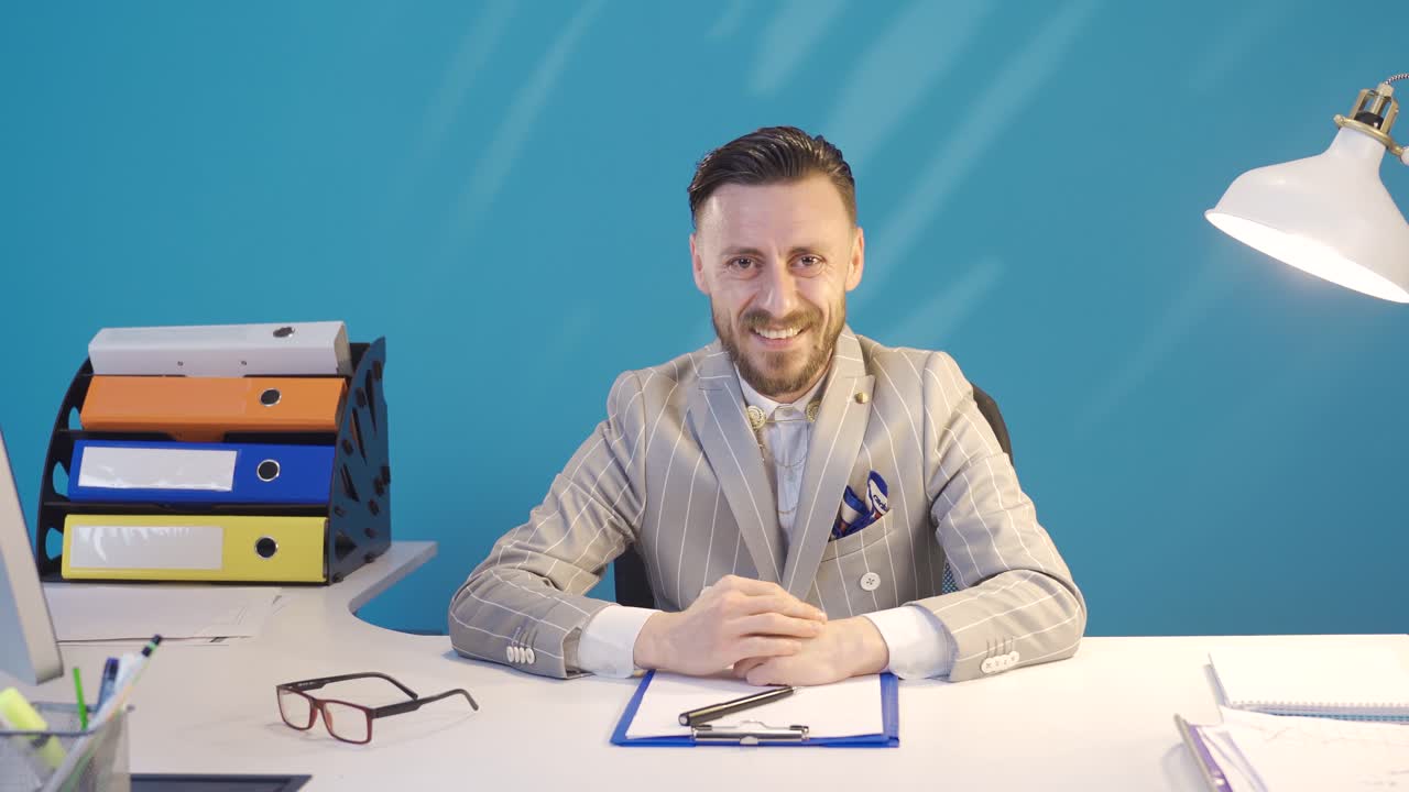 hombre de negocios con el principio de éxito mirando a la cámara sonriendo y dando una marca de verificación.