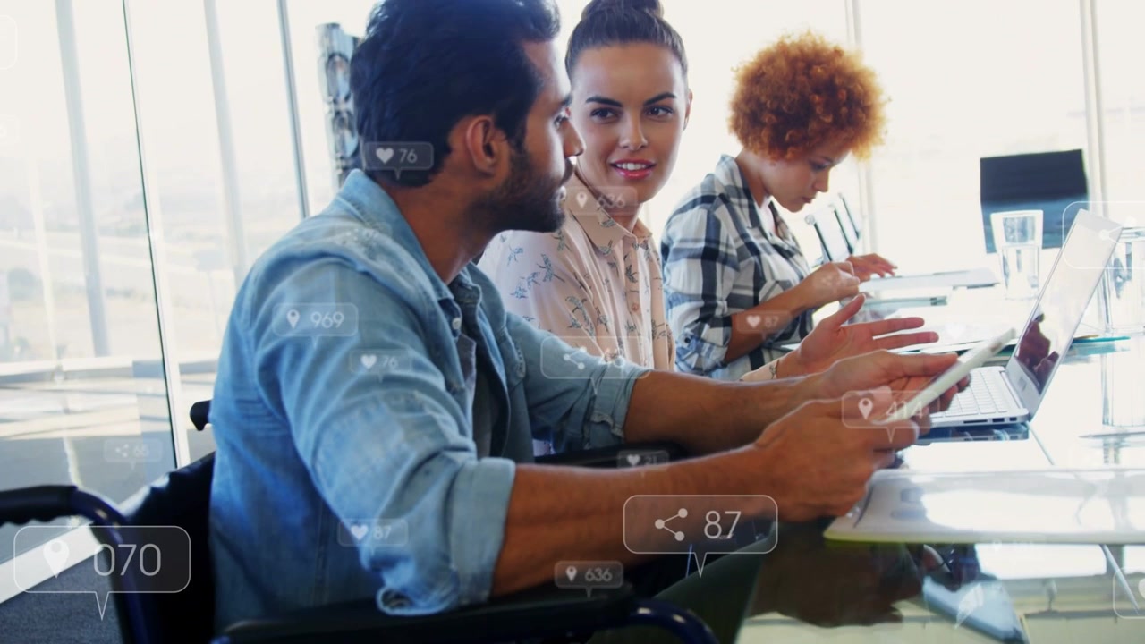 Man in chair swiping tablet sparking team review, animated metrics showing on screens for marketing