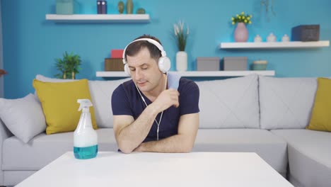 un hombre triste y deprimido se detiene y se quita los auriculares mientras limpia escuchando música.
