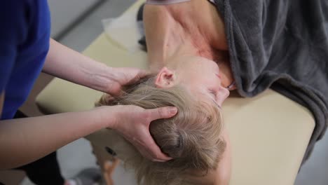 professional neck massage in spa salon. masseur working with senior woman.