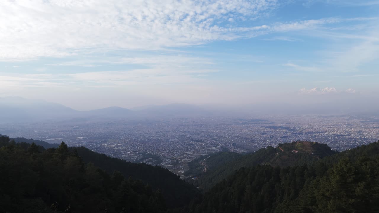 Experience Kathmandu from above as drones capture the cityscape framed by green mountains and a vibrant blue sky. Stunning aerial views highlight Nepal’s natural beauty and urban charm