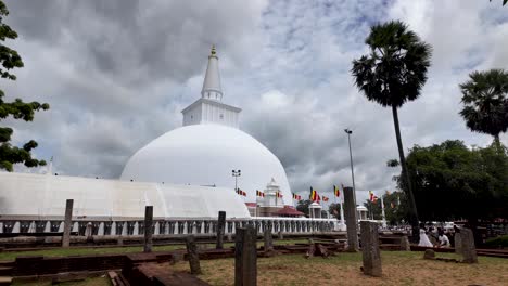 ruwanweli maha seya, a prominent stupa in anuradhapura, sri lanka, stands majestically among palm trees and historic surroundings. establishing shot