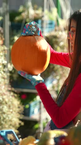 una mujer recogiendo una calabaza.