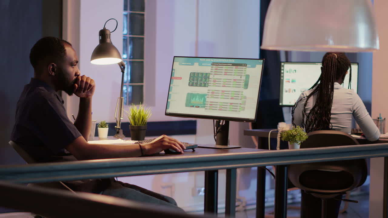 Man working on computer with financial data in office