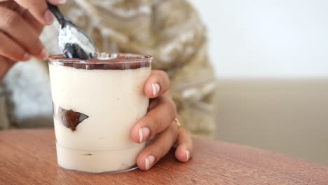 a woman eating tiramisu dessert