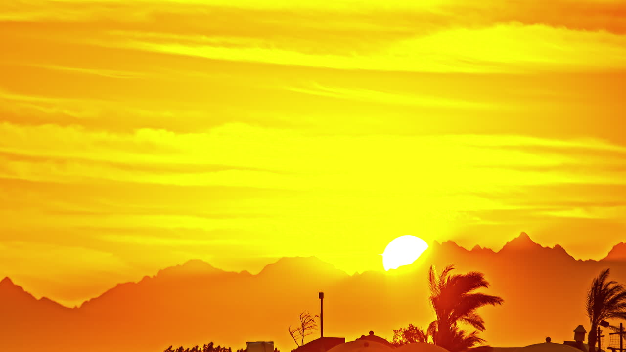 таймлапс в горах хургады с оранжевым солнцем, пробивающимся сквозь облака, египет