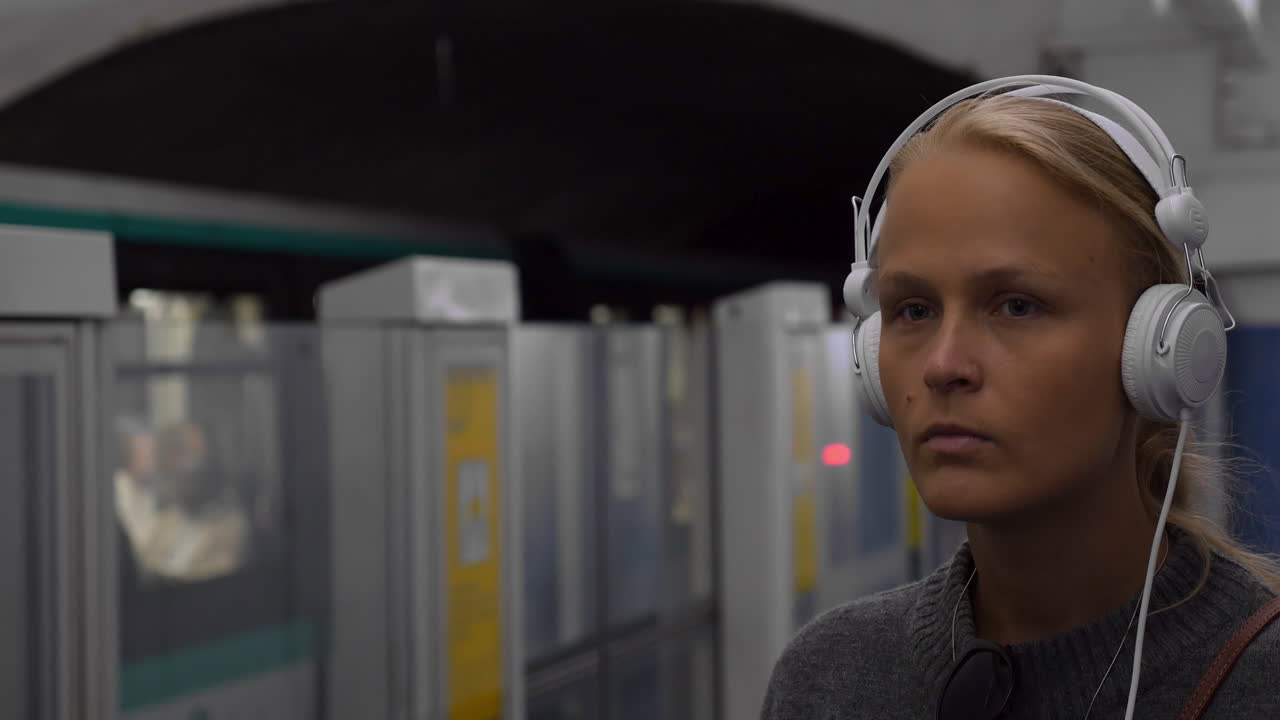 mujer urbana escuchando música en el subterráneo
