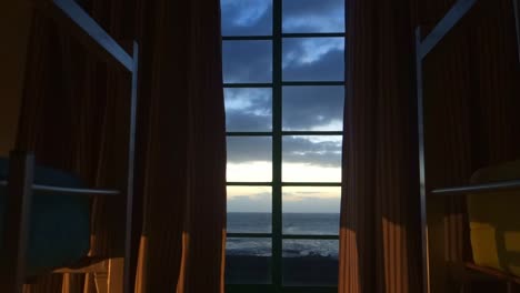 vista de una ventana y cortina hacia el mar