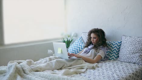 mujer trabajando en la computadora portátil en la cama