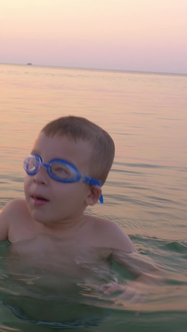 Boy swimming at the beach during sunset