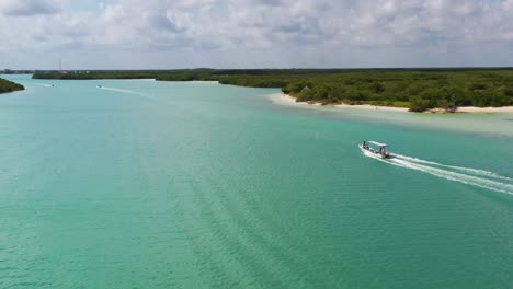 video de vista aérea tomado por un dron de un bote en una playa de arena tropical caribeña con agua turquesa - zafiro, laguna de río lagartos, méxico