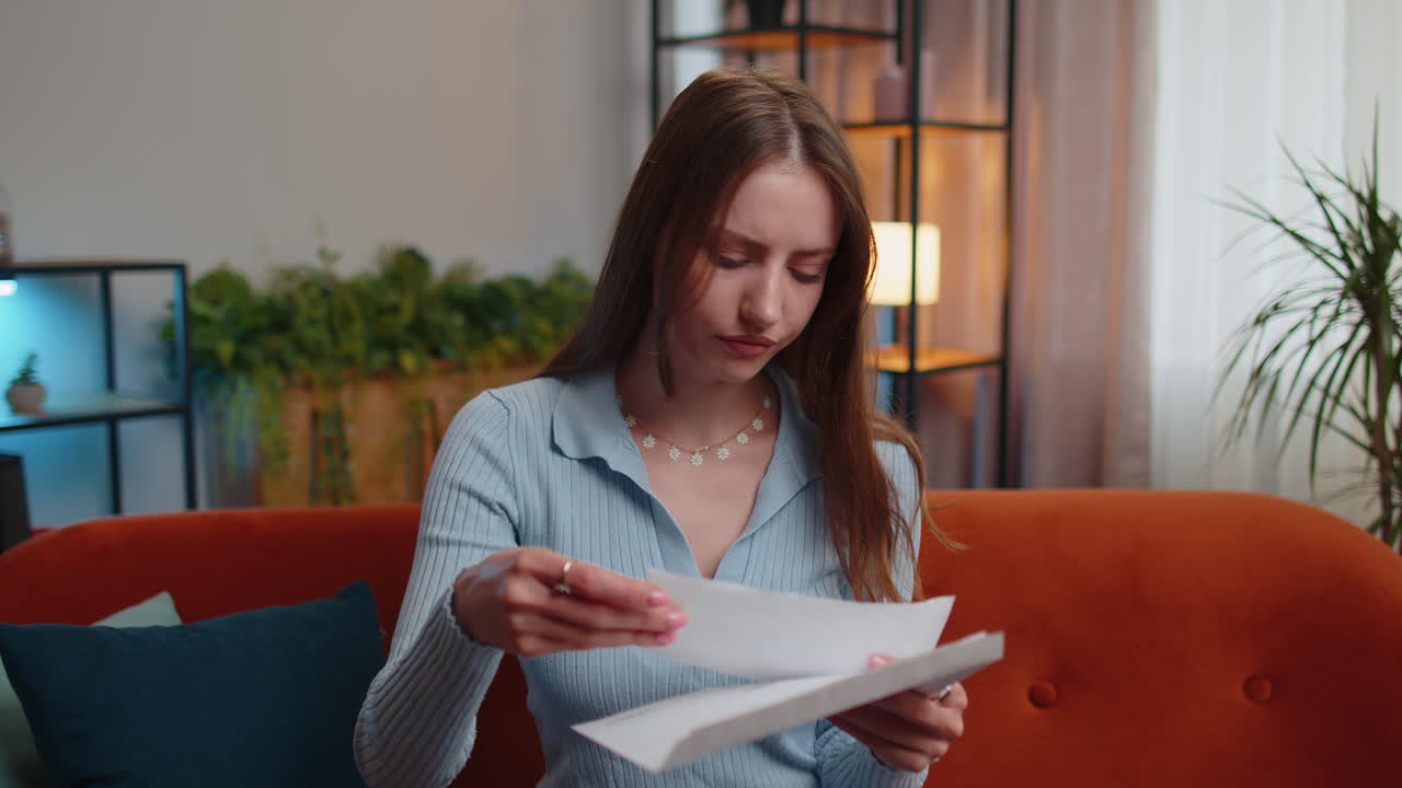 Kvinde åbner brev, læser det og bliver glad over karrierevækst, avancement, forfremmelse eller godkendt banklån.