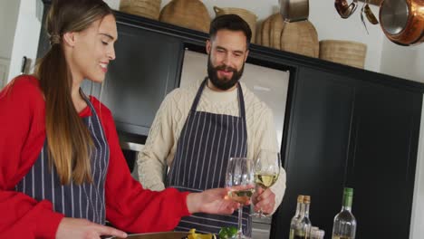 video of happy caucasian couple cooking and drinking wine