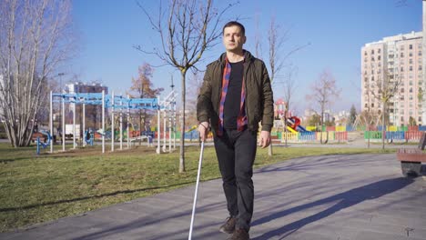 Blind-man-walking-alone-on-the-road.-He-has-a-cane.