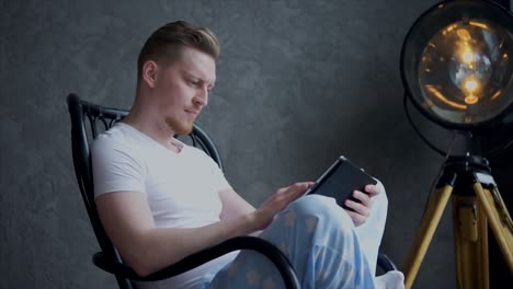 man using tablet in a chair