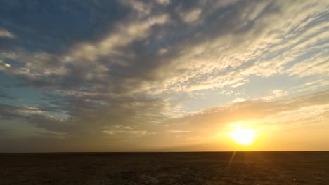 time lapse during late evening in the little rann of kutch a flat landscape and amazing cloud movement in gujarat india , orange sun flat horizon