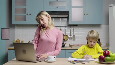 mother working from home while son does homework