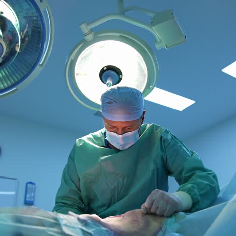 surgical intervention. professional doctor performing liposuction procedure under medical lamp. fat removal in modern clinic. view from below
