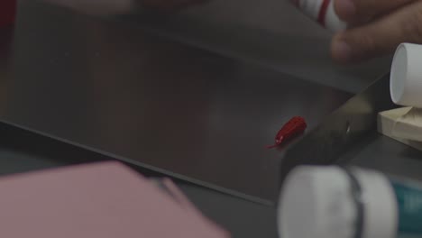 a man pouring textile ink for linen stamp varnishing process by hands