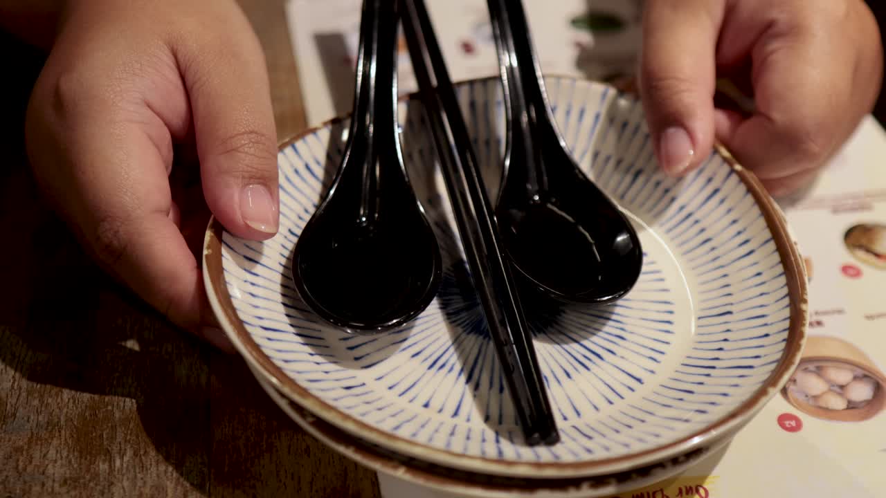 manos arreglando cucharas y panes al vapor