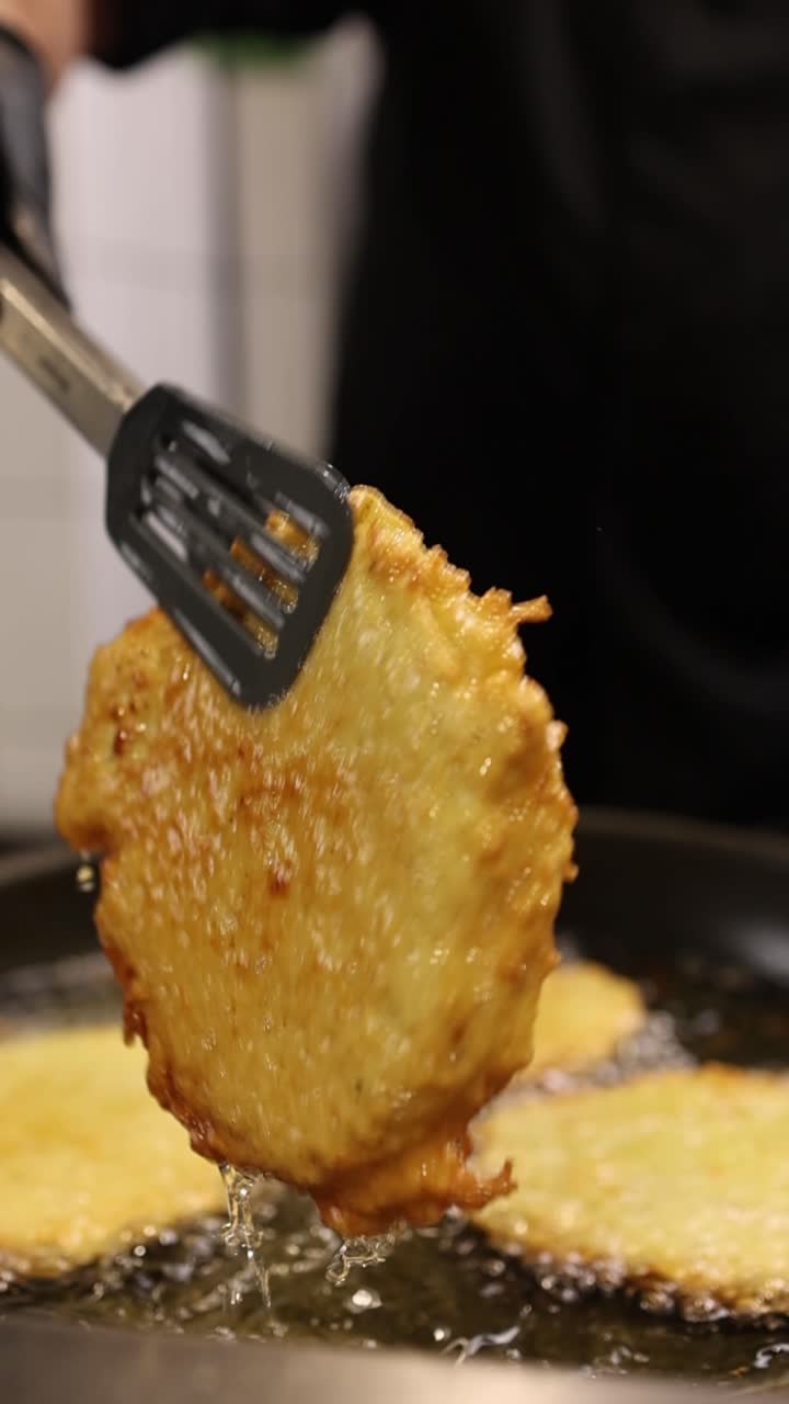 Chef che frigge frittelle di patate dorate nell'olio caldo