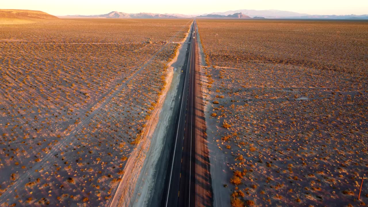 US, NV, Amargossa Valley, Hwy 95, 2025-01-15 - Drone view of the highway running straight into the distance at sunset surrounded by empty desert