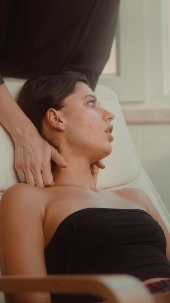 Ung kvinde, der får afslappende nakke- og hovedmassage.