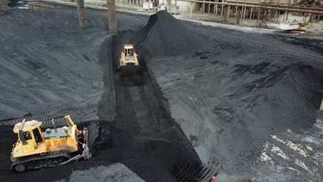 tracor raking coal. moving tractor coal around plant for processing