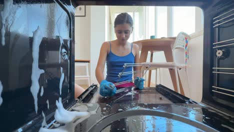 woman cleaning oven interior