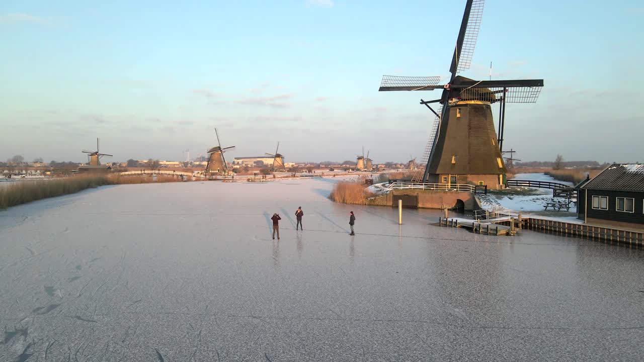 Vista aerea di mulini a vento e paesaggio ghiacciato invernale all'alba a Kinderdijk, Paesi Bassi, con una splendida illuminazione all'alba, atmosfera calma, riprese drone di alta qualità che mostrano paesaggi meravigliosi