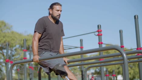 atleta con pierna protésica haciendo levantamientos de piernas colgantes.